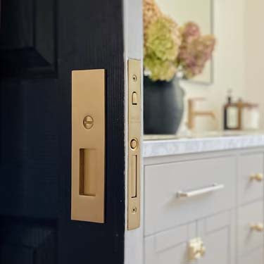 The Classic Passage Set in Polished Brass with Rice Door Knobs